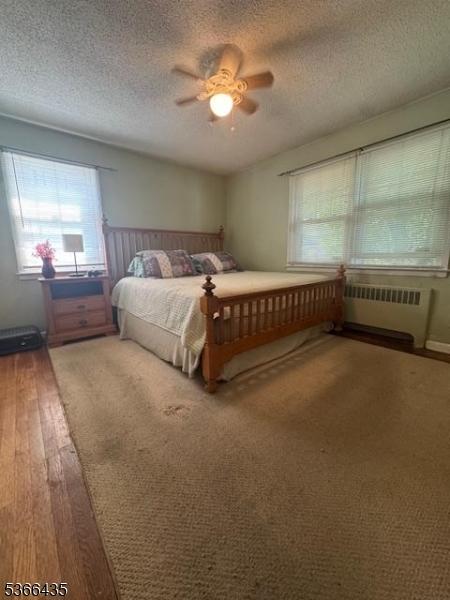 1221 Union St, Linden City, NJ 07036 - bedroom with radiator, hardwood / wood-style floors, a textured ceiling, and ceiling fan