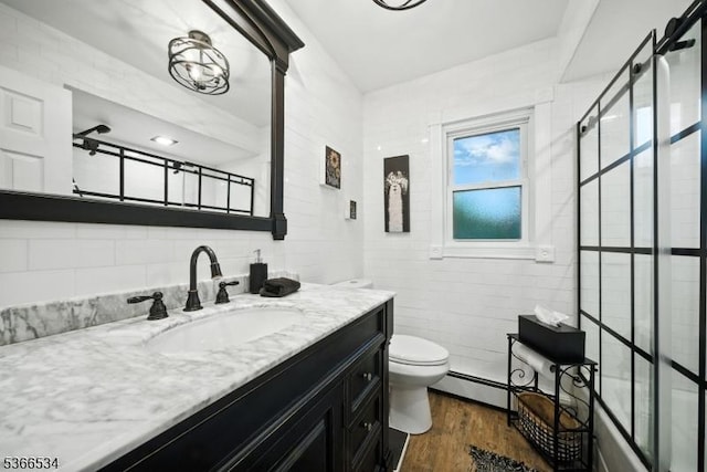 54 Pine Ln, West Milford Twp, NJ 07480 - full bath with vanity, a baseboard heating unit, wood finished floors, and shower / bath combination with glass door