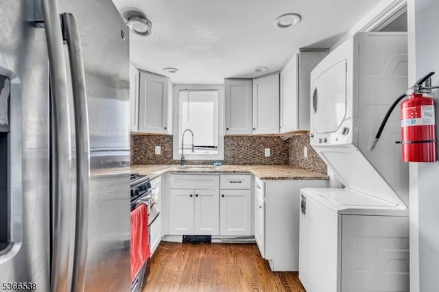 853 Westfield Ave, Rahway City, NJ 07065 - kitchen featuring appliances with stainless steel finishes, estacked washer and dryer, dark wood finished floors, light stone counters, and decorative backsplash