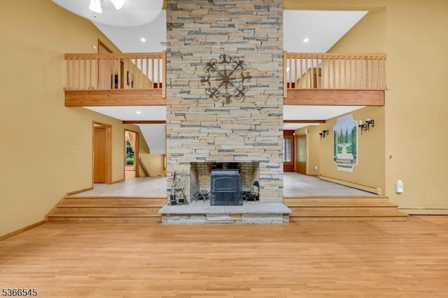 86 Underrock Rd, Sparta Twp, NJ 07871 - unfurnished living room featuring a high ceiling, stairs, wood finished floors, a baseboard heating unit, and a fireplace