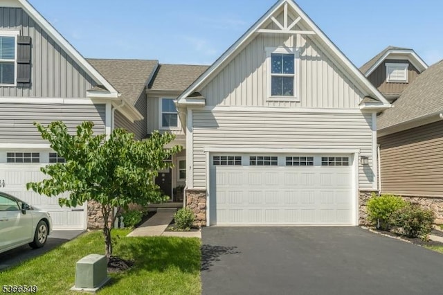 7 Harrier Ln, Washington Twp, NJ 07882 - view of front facade featuring board and batten siding, driveway, stone siding, an attached garage, and a shingled roof