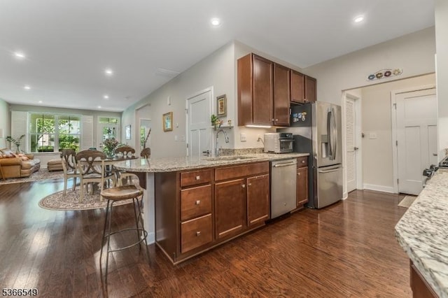 7 Harrier Ln, Washington Twp, NJ 07882 - kitchen featuring stainless steel appliances, dark wood-type flooring, a peninsula, open floor plan, and light stone counters
