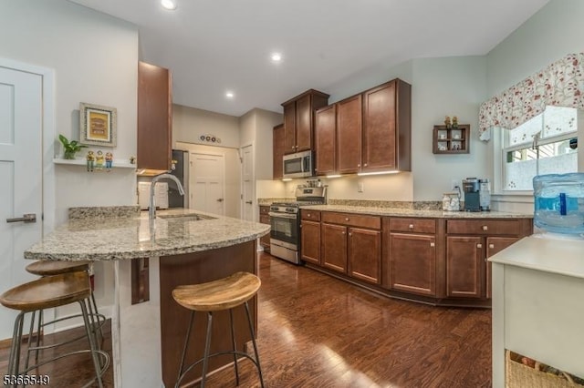 7 Harrier Ln, Washington Twp, NJ 07882 - kitchen with appliances with stainless steel finishes, dark wood-style flooring, a peninsula, light stone countertops, and a breakfast bar area