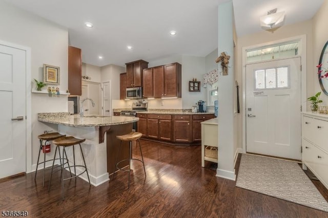 7 Harrier Ln, Washington Twp, NJ 07882 - kitchen featuring stainless steel appliances, dark wood-type flooring, a breakfast bar, light stone countertops, and a peninsula