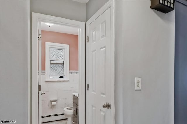 93 Meacham Ave, Nutley Twp, NJ 07110 - corridor featuring tile walls, a baseboard heating unit, a wainscoted wall, and tile patterned floors