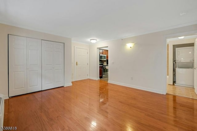 7 Prospect St Unit 510, Morristown Town, NJ 07960 - unfurnished bedroom with stacked washing machine and dryer, ornamental molding, light wood-type flooring, and a closet