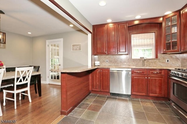 393 High St, Nutley Twp, NJ 07110 - kitchen featuring appliances with stainless steel finishes, a peninsula, recessed lighting, decorative backsplash, and glass insert cabinets