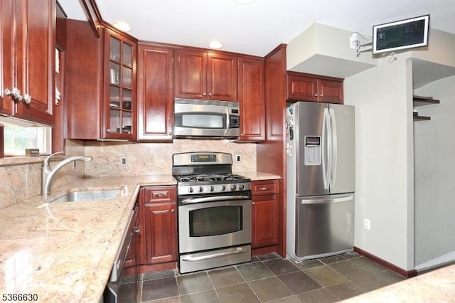 393 High St, Nutley Twp, NJ 07110 - kitchen with stainless steel appliances, light stone counters, backsplash, glass insert cabinets, and reddish brown cabinets