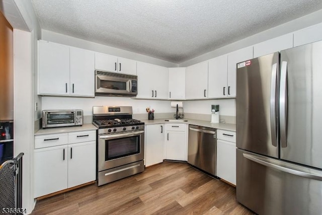 204 Robertson Way Unit 204, Lincoln Park Boro, NJ 07035 - kitchen featuring appliances with stainless steel finishes, light countertops, white cabinets, dark wood finished floors, and a textured ceiling