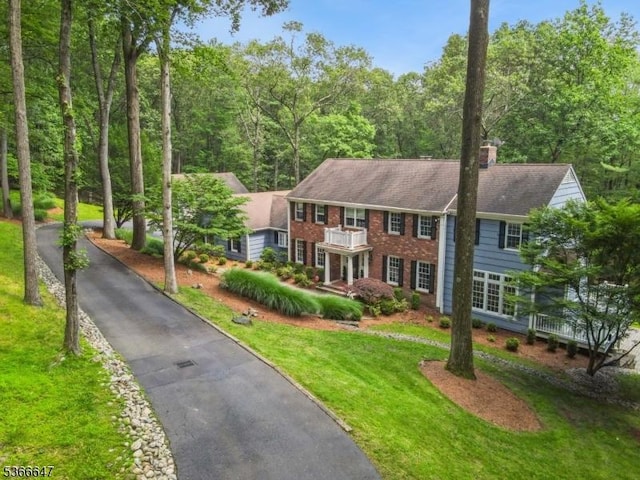 22 Saddle Hill Rd, Mendham Twp, NJ 07931 - view of front of home with a balcony, brick siding, a front yard, and a chimney