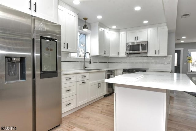 584 Lake Shore Dr, West Milford Twp, NJ 07421 - kitchen with stainless steel appliances, white cabinetry, tasteful backsplash, light wood-style flooring, and recessed lighting