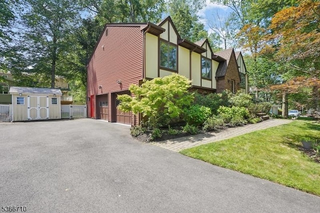 15 Woglum Pl, Berkeley Heights Twp, NJ 07922 - view of side of home featuring a garage, asphalt driveway, a storage unit, and stucco siding