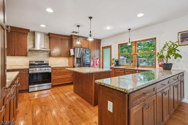 15 Woglum Pl, Berkeley Heights Twp, NJ 07922 - kitchen with appliances with stainless steel finishes, wall chimney exhaust hood, brown cabinets, a center island, and light wood-style floors