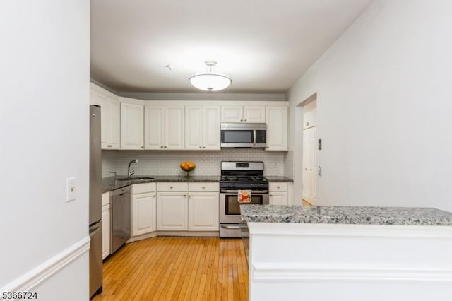 227 Potomac Dr, Bernards Twp, NJ 07920 - kitchen with stainless steel appliances, decorative backsplash, white cabinets, and light wood-type flooring