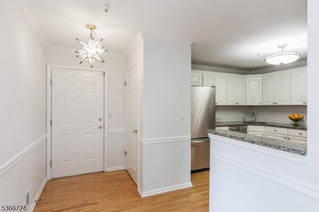227 Potomac Dr, Bernards Twp, NJ 07920 - kitchen with appliances with stainless steel finishes, tasteful backsplash, white cabinetry, a chandelier, and light wood-type flooring