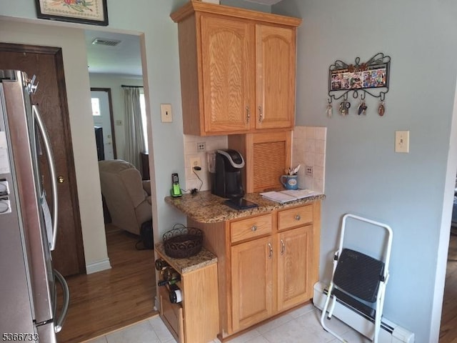 21 Fagan Pl, Woodbridge Twp, NJ 07067 - kitchen with freestanding refrigerator, tasteful backsplash, light stone counters, a baseboard heating unit, and light tile patterned flooring