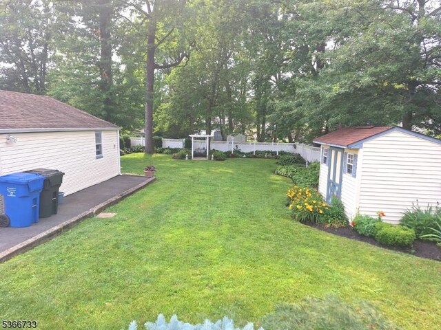 21 Fagan Pl, Woodbridge Twp, NJ 07067 - fenced backyard featuring an outbuilding and a wooden deck