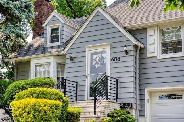 608 Duquesne Ter, Union Twp, NJ 07083 - view of front of house featuring a chimney, a garage, and a shingled roof