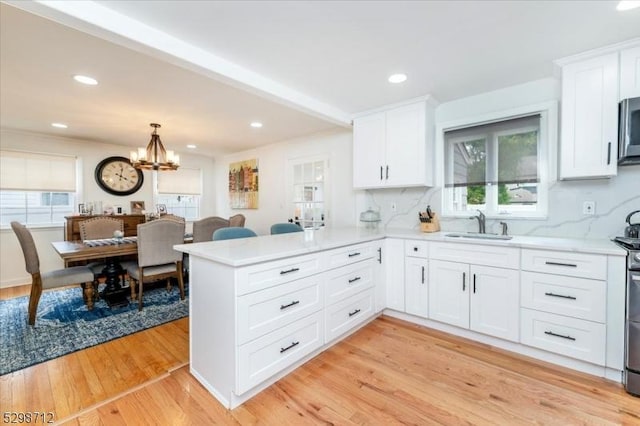 608 Duquesne Ter, Union Twp, NJ 07083 - kitchen featuring a peninsula, healthy amount of natural light, a chandelier, white cabinetry, and recessed lighting