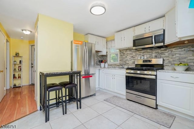 139 Churchill Ave, Franklin Twp, NJ 08873 - kitchen with appliances with stainless steel finishes, tasteful backsplash, white cabinets, and light tile patterned floors
