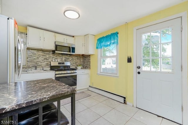 139 Churchill Ave, Franklin Twp, NJ 08873 - kitchen featuring appliances with stainless steel finishes, a baseboard heating unit, backsplash, and light tile patterned floors