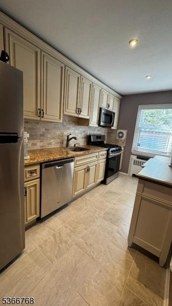 53 Sandra Cir Unit 4, Westfield Town, NJ 07090 - kitchen with appliances with stainless steel finishes, decorative backsplash, cream cabinetry, recessed lighting, and radiator heating unit