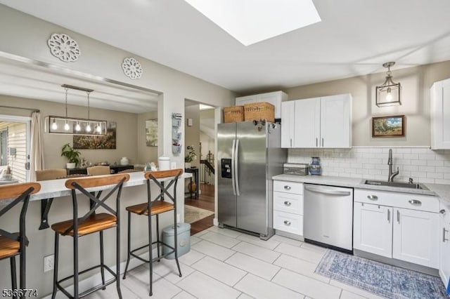 159 Kings Hwy, Washington Twp, NJ 07853 - kitchen with appliances with stainless steel finishes, a kitchen breakfast bar, light countertops, tasteful backsplash, and hanging light fixtures