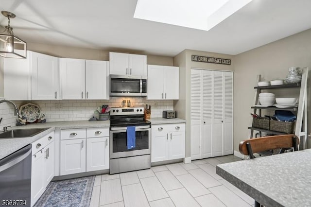 159 Kings Hwy, Washington Twp, NJ 07853 - kitchen featuring stainless steel appliances, light countertops, tasteful backsplash, white cabinets, and pendant lighting