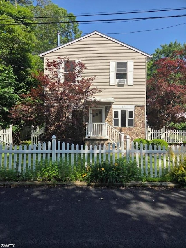 25 Alabama Ave, Jefferson Twp, NJ 07849 - view of front facade with stone siding, a fenced front yard, and cooling unit