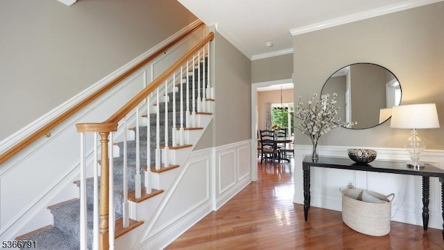 31 Burniston Ct, Hillsborough Twp, NJ 08844 - staircase with crown molding, wood finished floors, wainscoting, a decorative wall, and a chandelier