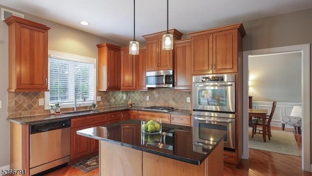 31 Burniston Ct, Hillsborough Twp, NJ 08844 - kitchen with stainless steel appliances, light wood-type flooring, a kitchen island, dark countertops, and tasteful backsplash