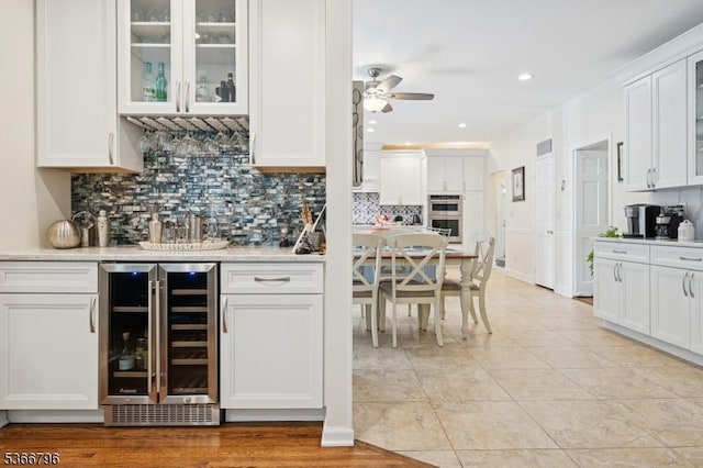 17 N Ridge Rd, Denville Twp, NJ 07834 - indoor dry bar with beverage cooler, stainless steel double oven, decorative backsplash, a ceiling fan, and recessed lighting