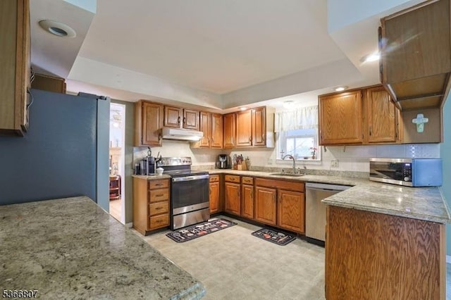 4 Panorama Dr, Vernon Twp, NJ 07461 - kitchen featuring stainless steel appliances, a raised ceiling, under cabinet range hood, brown cabinets, and light stone countertops