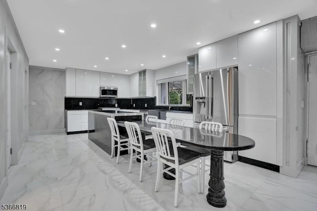 85 Francisco Ave, Little Falls Twp, NJ 07424 - kitchen with modern cabinets, light marble finish flooring, appliances with stainless steel finishes, white cabinetry, and glass insert cabinets