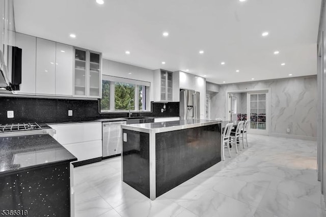 85 Francisco Ave, Little Falls Twp, NJ 07424 - kitchen with appliances with stainless steel finishes, modern cabinets, light marble finish floors, a kitchen island, and recessed lighting