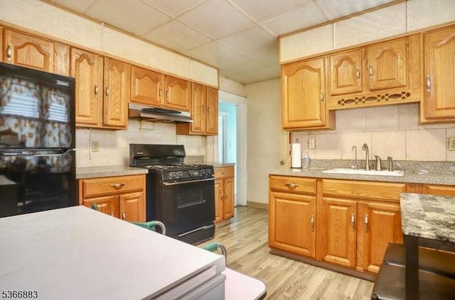 10-12 Medbourne Ave, Irvington Twp, NJ 07111 - kitchen featuring black appliances, under cabinet range hood, decorative backsplash, light countertops, and light wood finished floors