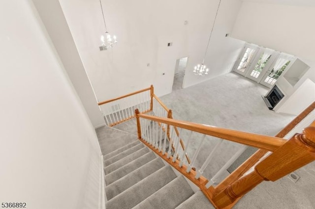7303 Ravenscroft Rd Unit 7303, Clifton City, NJ 07013 - stairs featuring a chandelier, carpet floors, a towering ceiling, and a fireplace