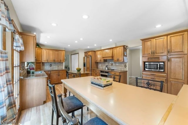 357 Minute Arms Rd, Union Twp, NJ 07083 - kitchen featuring stainless steel appliances, backsplash, a kitchen bar, recessed lighting, and light wood-style flooring