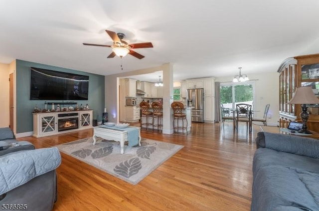 417 Mountain Rd, Readington Twp, NJ 08833 - living area with a chandelier, ceiling fan, light wood-type flooring, and a glass covered fireplace