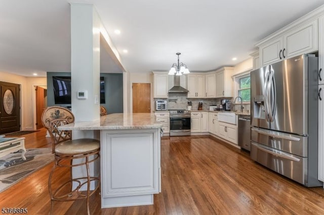 417 Mountain Rd, Readington Twp, NJ 08833 - kitchen featuring appliances with stainless steel finishes, wall chimney range hood, light stone counters, a chandelier, and decorative backsplash