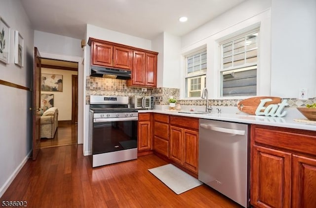 227 Parker Ave, Maplewood Twp, NJ 07040 - kitchen featuring stainless steel appliances, under cabinet range hood, backsplash, dark wood finished floors, and light countertops