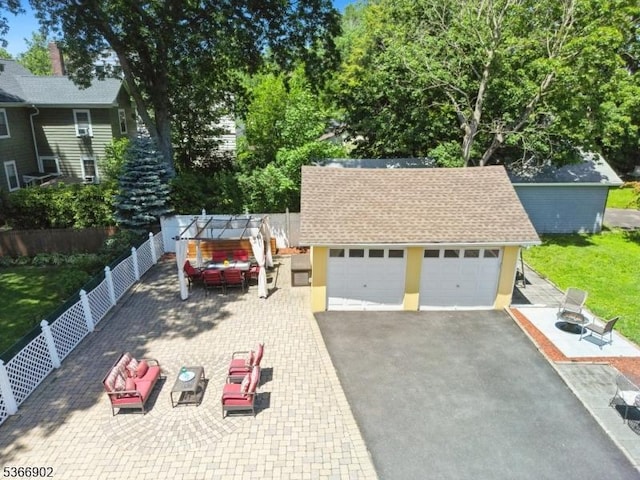 227 Parker Ave, Maplewood Twp, NJ 07040 - view of front facade with an outdoor structure, a fenced backyard, asphalt driveway, stucco siding, and roof with shingles