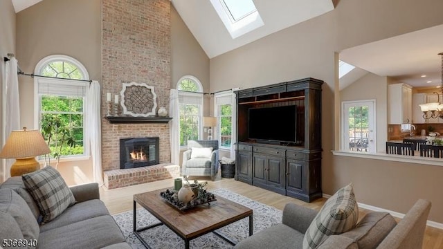 24 Montfort Dr, Montgomery Twp, NJ 08502 - living area featuring high vaulted ceiling, plenty of natural light, a skylight, a brick fireplace, and light wood-style floors