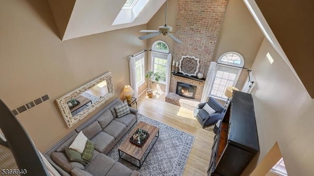 24 Montfort Dr, Montgomery Twp, NJ 08502 - living room featuring high vaulted ceiling, healthy amount of natural light, a fireplace, a skylight, and wood finished floors