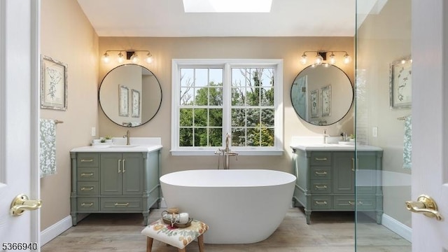 24 Montfort Dr, Montgomery Twp, NJ 08502 - full bathroom featuring two vanities, a freestanding bath, a skylight, and wood finished floors