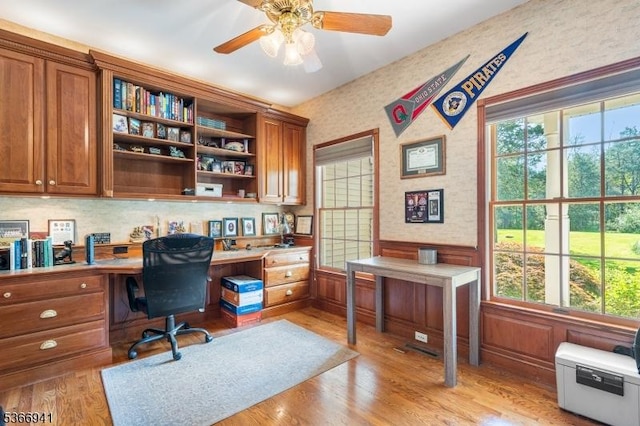 21 Partridge Rd, Readington Twp, NJ 08822 - home office with built in desk, a wainscoted wall, a ceiling fan, wallpapered walls, and light wood-style floors