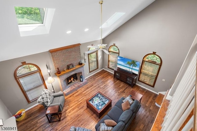 21 Partridge Rd, Readington Twp, NJ 08822 - living room featuring a skylight, high vaulted ceiling, a ceiling fan, a brick fireplace, and wood finished floors