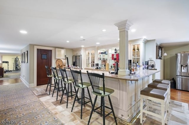 141 Mountaintop Rd, Bernardsville Boro, NJ 07924 - kitchen with stainless steel refrigerator with ice dispenser, a kitchen breakfast bar, a peninsula, decorative columns, and recessed lighting