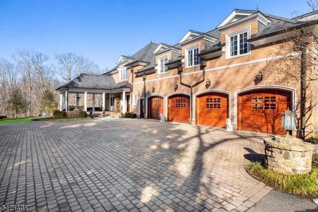 141 Mountaintop Rd, Bernardsville Boro, NJ 07924 - view of front of house with driveway, an attached garage, brick siding, and covered porch