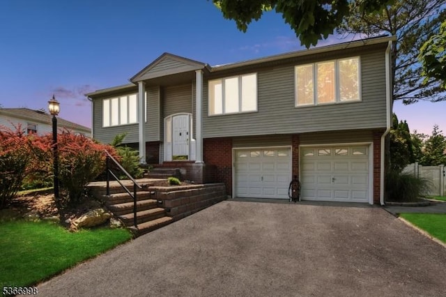 23 Midway Ct, Rockaway Twp, NJ 07866 - split foyer home featuring a garage, asphalt driveway, and brick siding